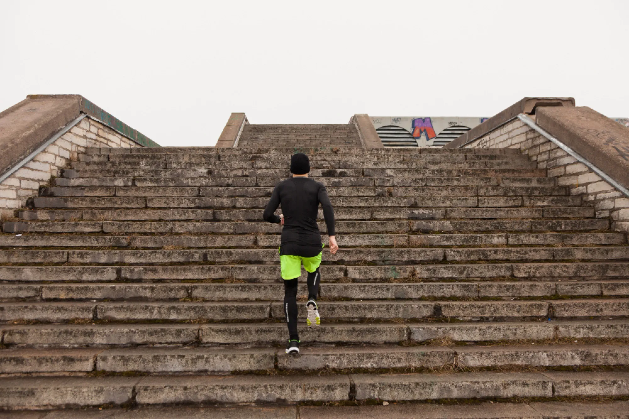 Coureur montant un grand escalier de pierre en ville